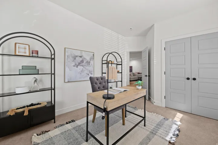 Bedroom #3 Staged as an office. Carpeted room with white walls, light gray paneled doors, and an open doorway