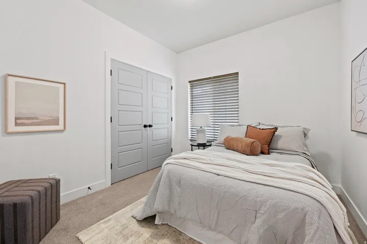 Bedroom #2 Neutral wall paint with carpet flooring, a window with horizontal blinds, and a built-in closet with paneled double doors