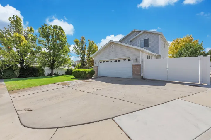 Two-story property featuring light-colored siding, a two-car garage, and a concrete driveway