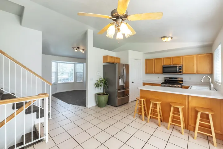 Kitchen featuring wood-finish cabinetry, stainless steel appliances, and a breakfast bar with solid surface countertops