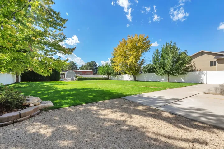 Expansive grass lawn bordered by a white privacy fence