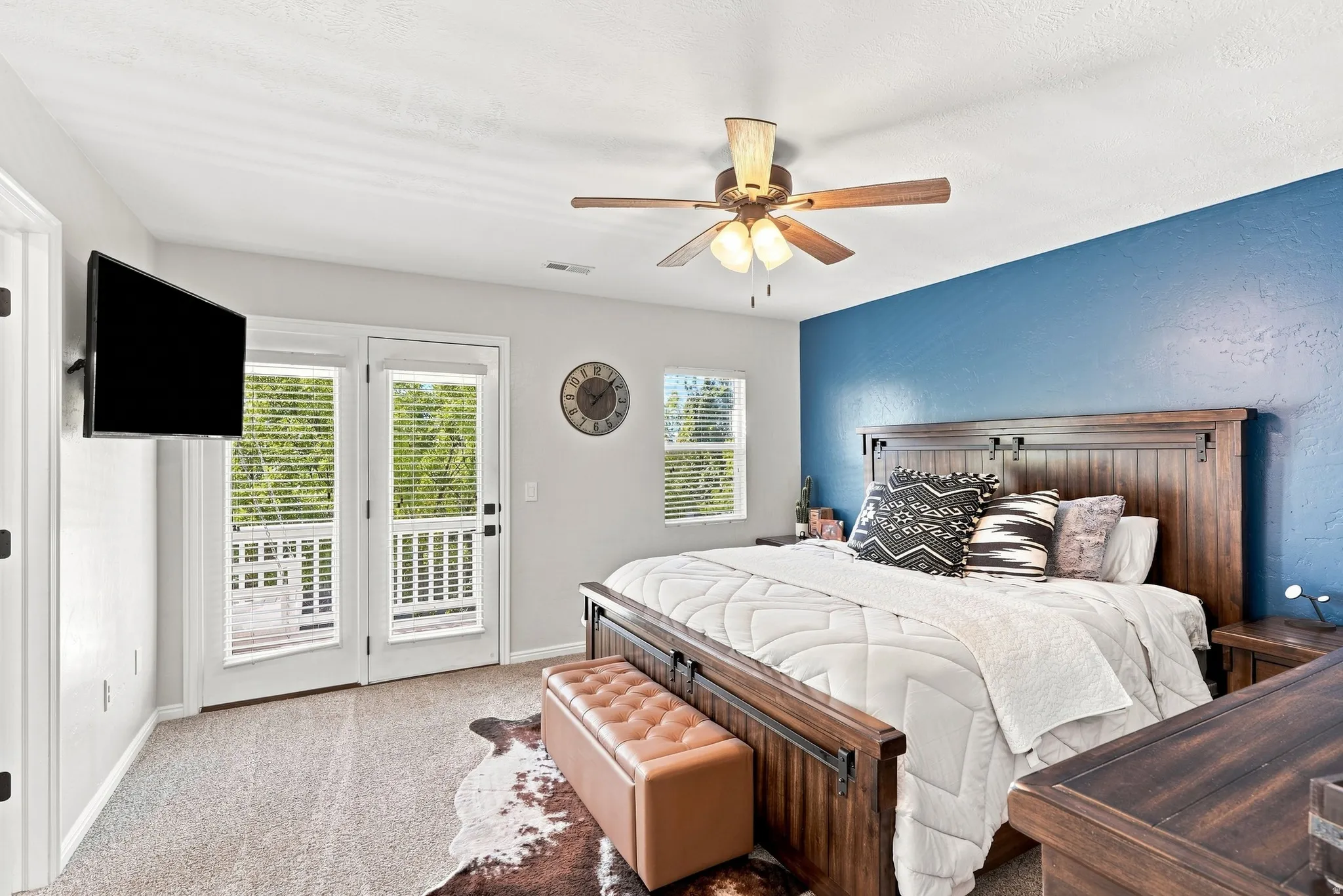 Room featuring twin French doors, a ceiling fan with integrated lighting, and neutral carpeting