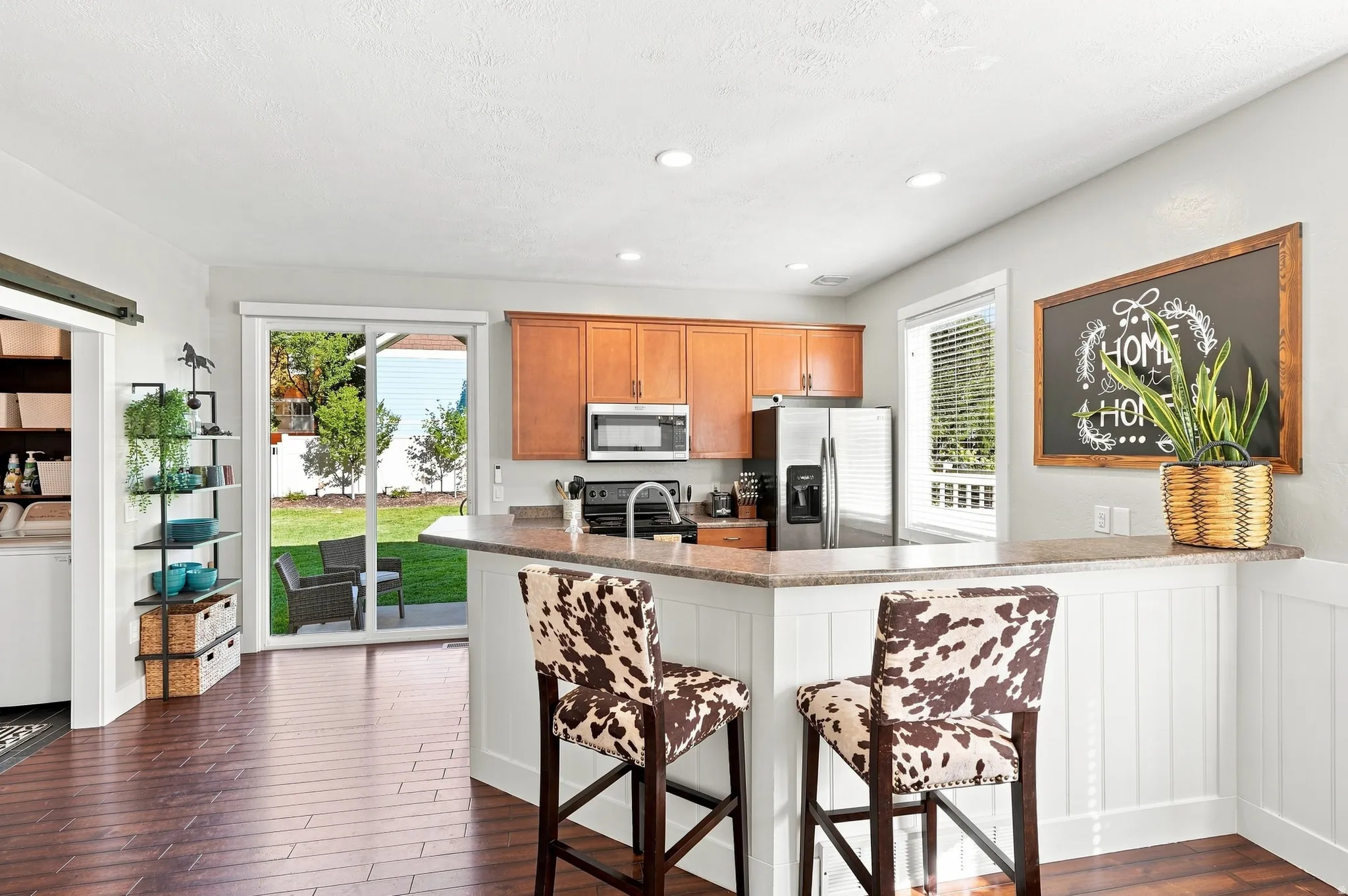 Kitchen featuring wood-finish flooring, recessed lighting, and a multi-level breakfast bar with a stone-finish countertop