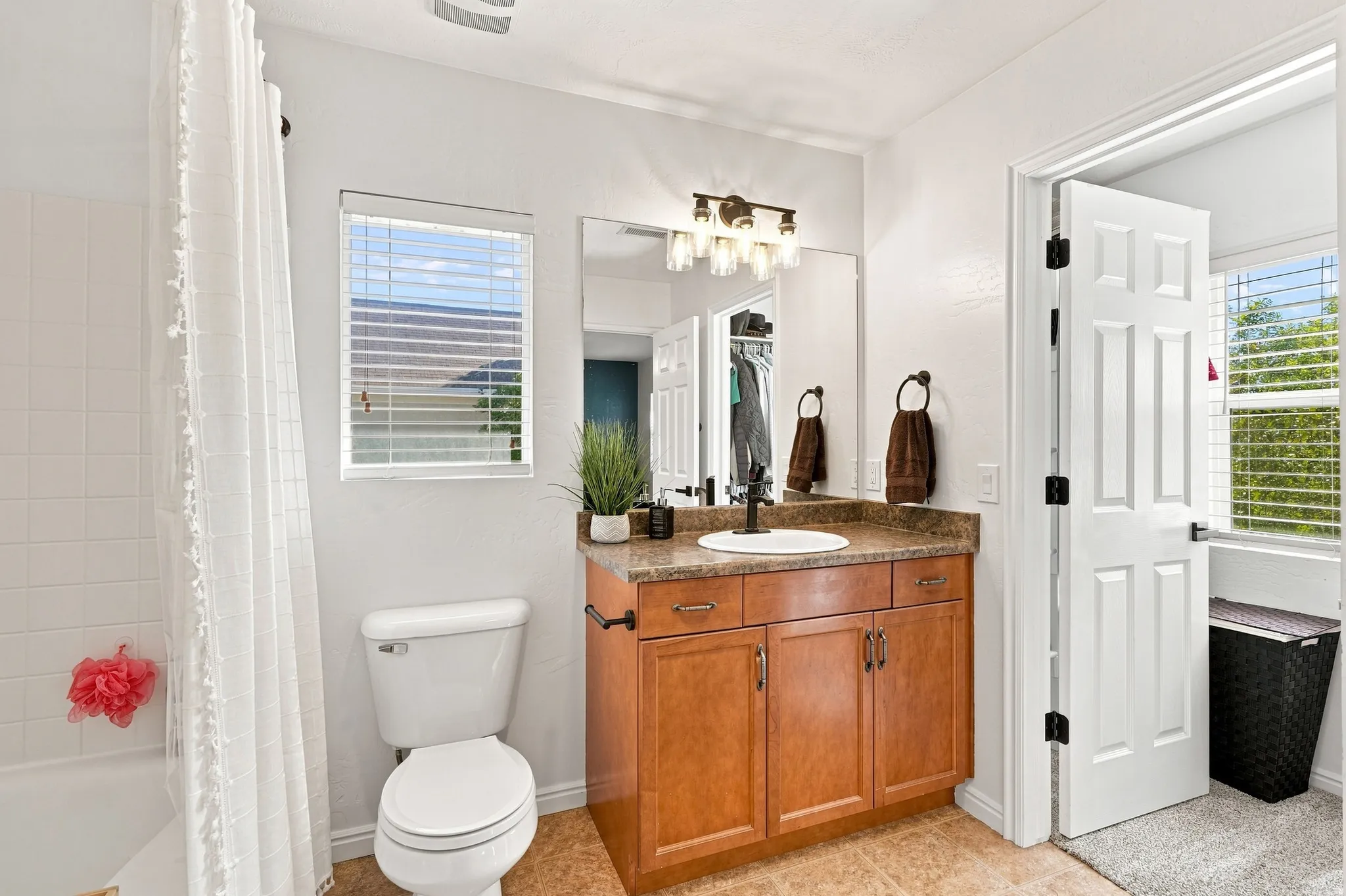 Single vanity with an integrated sink, bronze-finish faucet, and coordinating light fixture