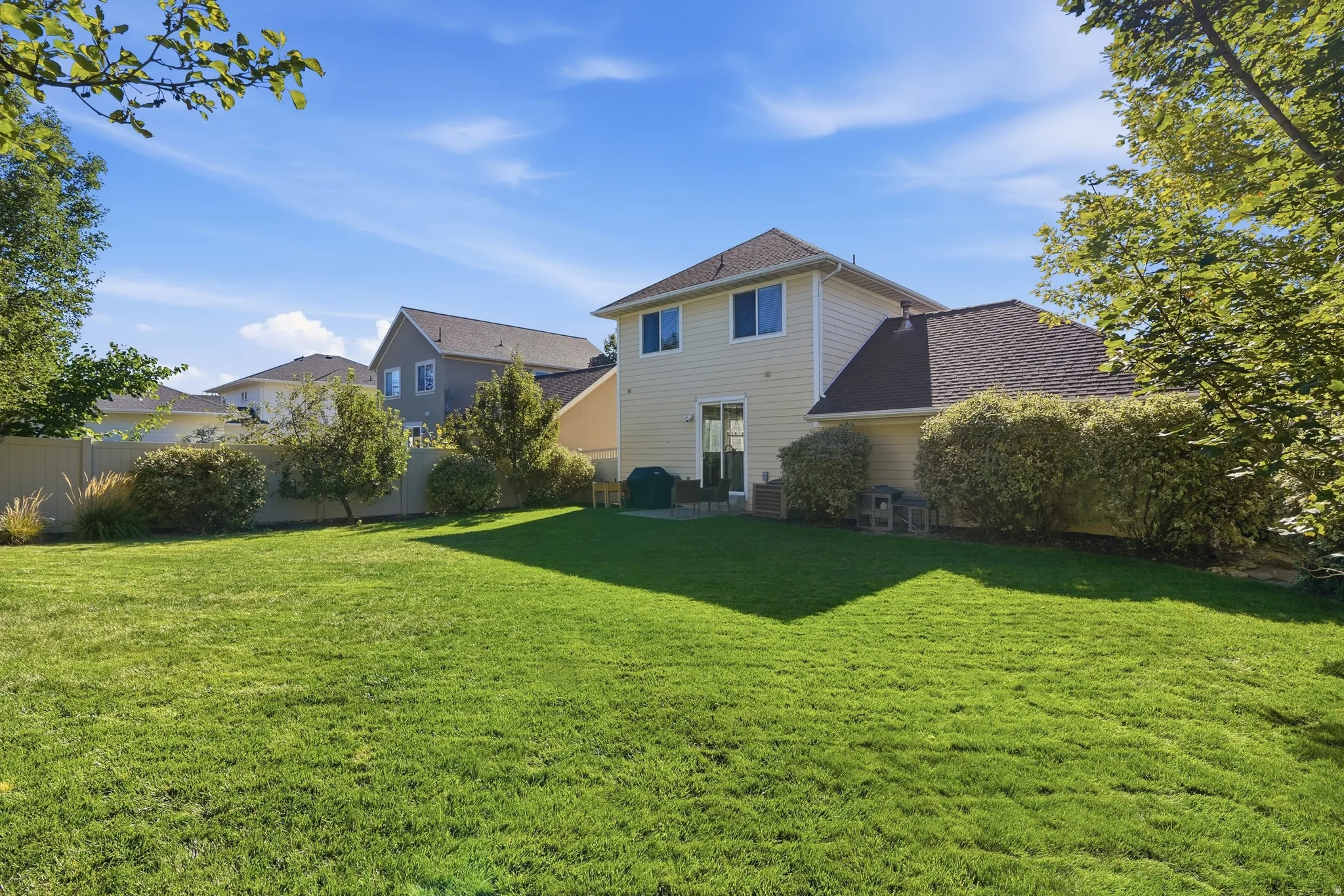 Expansive lawn area with a perimeter fence and mature landscaping
