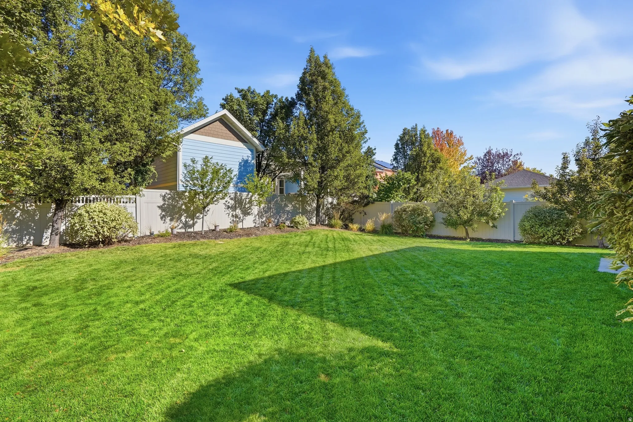 Expansive lawn area with mature trees and perimeter fencing