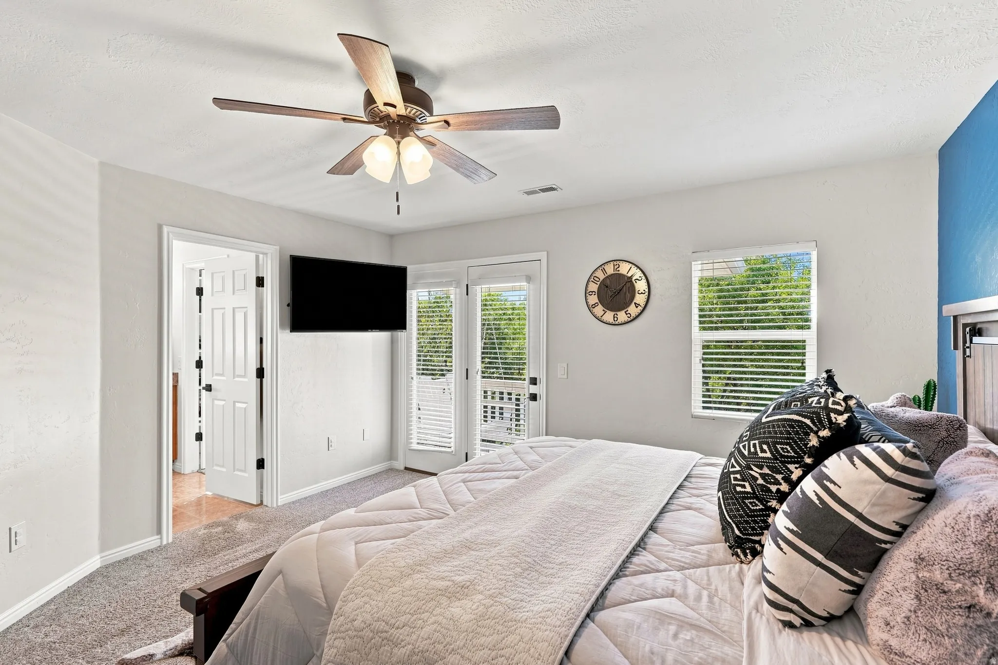 Ceiling fan with light fixture, carpeted flooring, window with blinds, and white paneled doors
