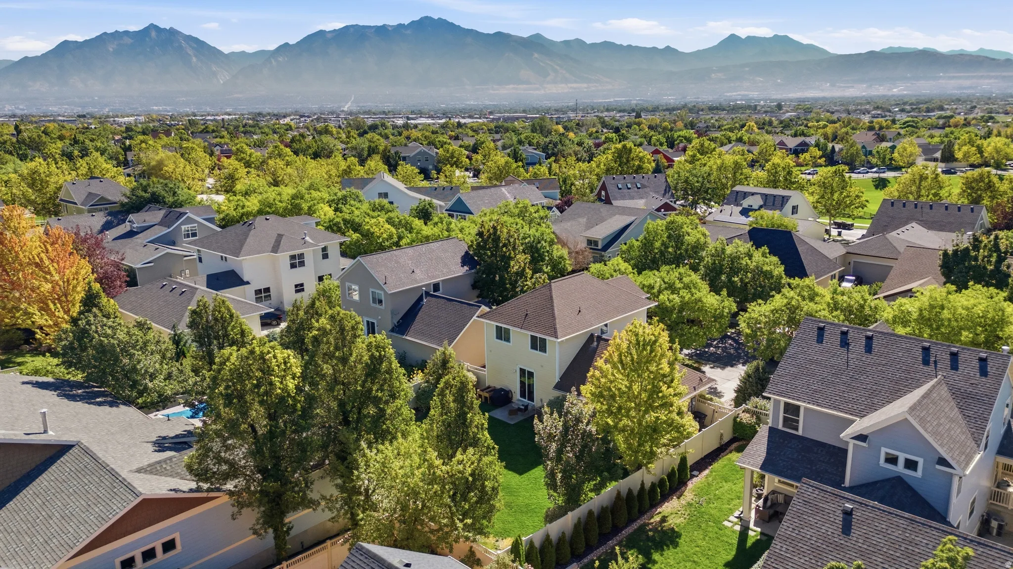Expansive suburban setting with established homes, mature trees, and mountainous backdrop