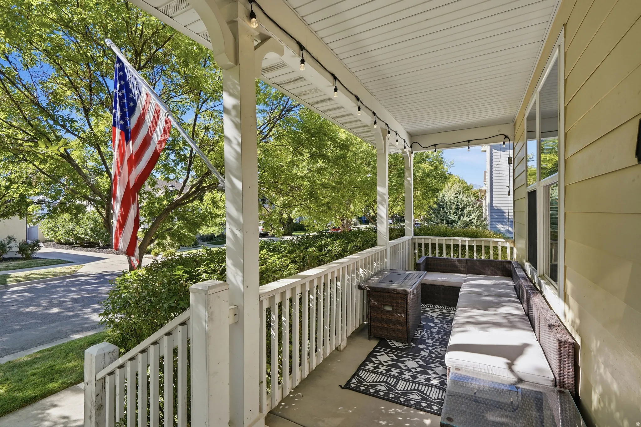 Covered porch featuring white railings, a light-colored soffit ceiling, and exterior siding