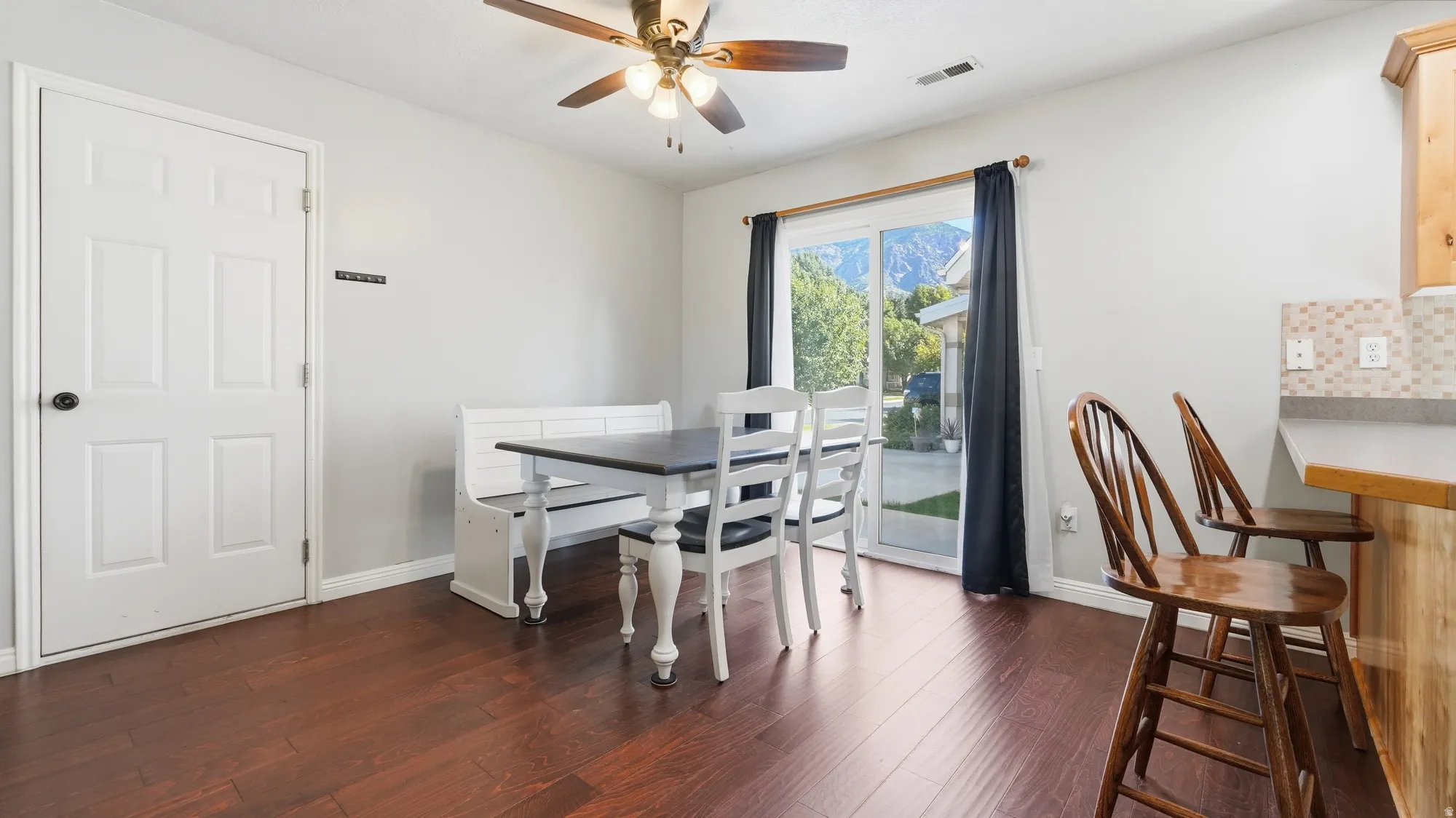 Bright dining area with beautiful flooring, sliding glass door for backyard access, and plenty of space for a full dining set.