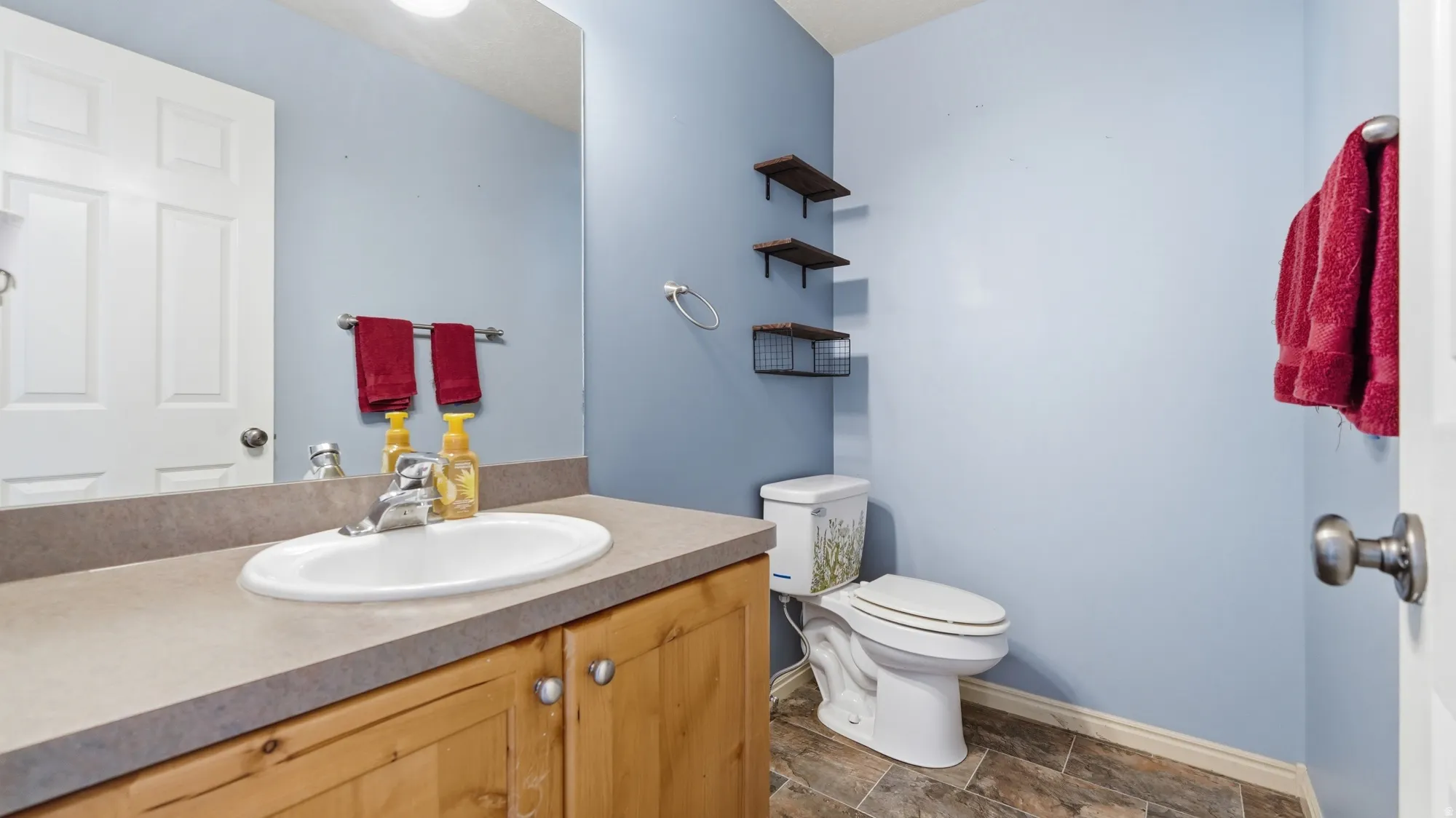 Convenient main-level half bathroom with updated flooring and plenty of vanity storage.