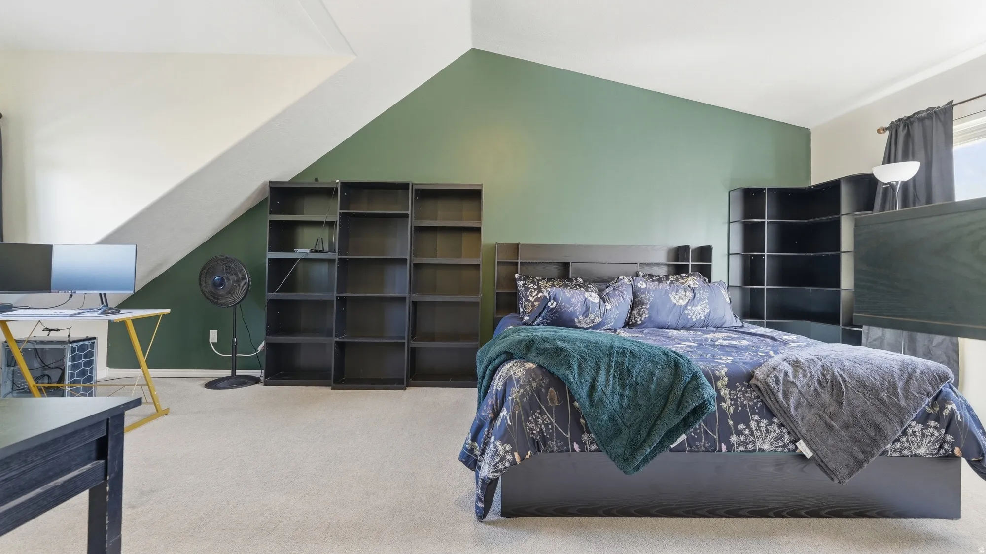 Spacious primary bedroom with vaulted ceiling, abundant floor space, and plenty of room for additional furniture or a home office setup.