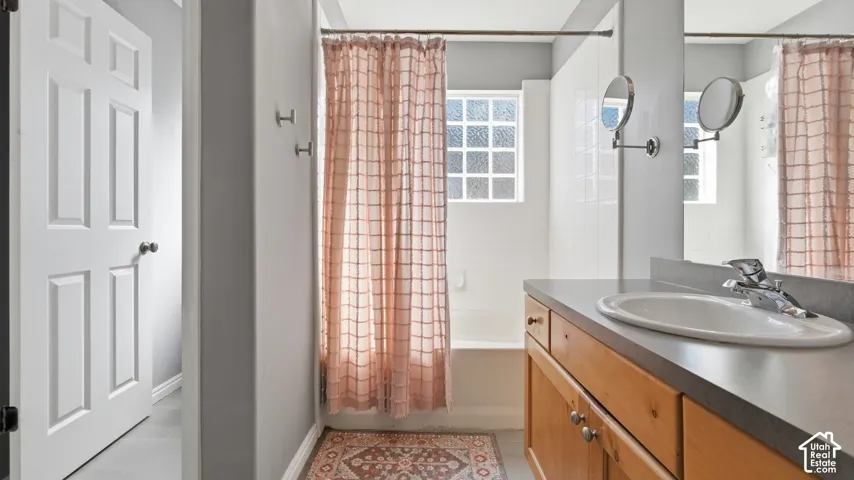 Primary bathroom features a tub/shower combination, vanity storage, large mirror, and a bright window for natural light.