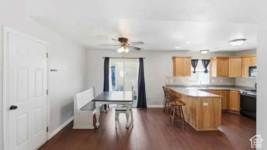 Open kitchen and dining area with beautiful LVP flooring, generous cabinetry, breakfast bar seating, and access to the outdoor patio.