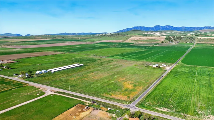 Expansive agricultural land featuring multiple cultivated fields and established outbuildings