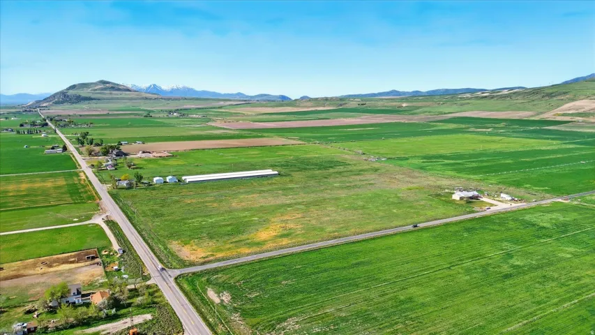 Expansive agricultural land featuring cultivated fields and distant mountain ranges