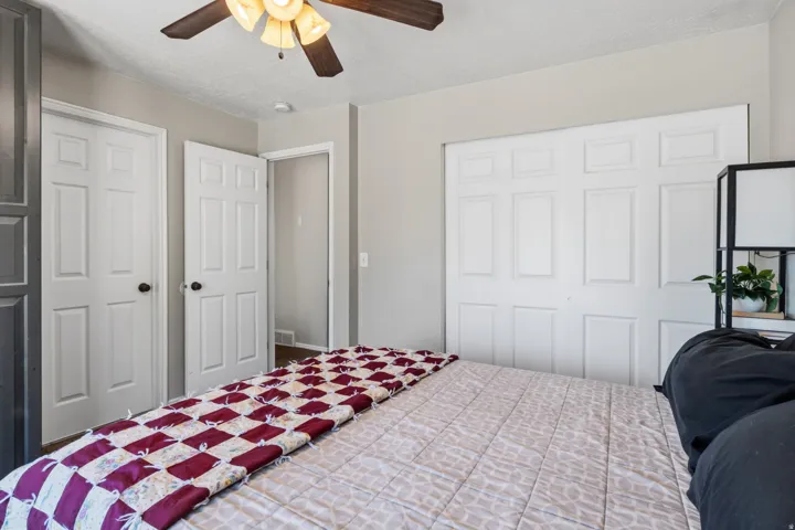 Panel doors, ceiling fan with light fixture, light gray wall paint, and white trim