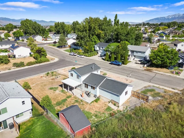 Two-story residence featuring a covered patio, a detached shed, a fenced perimeter, and a gravel driveway