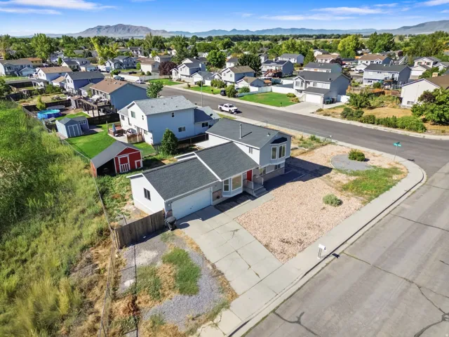 Corner lot property with a two-story residence, attached garage, and a gravel front yard