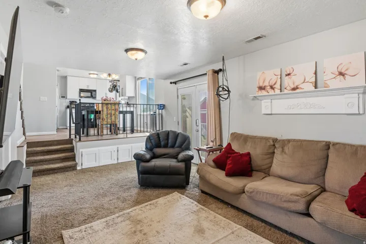 Carpeted flooring, vaulted ceiling, built-in wall shelf, flush mount ceiling lights, and white trim work