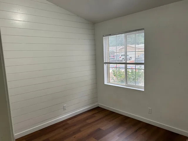 Wood-finish flooring, white shiplap accent wall, white window blinds