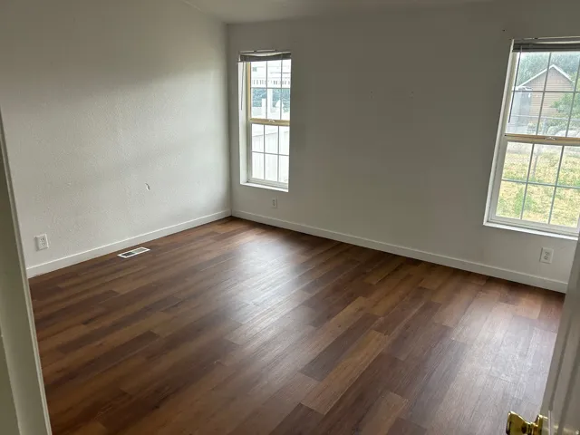 Wood-finish flooring throughout, complemented by dual windows and white trim