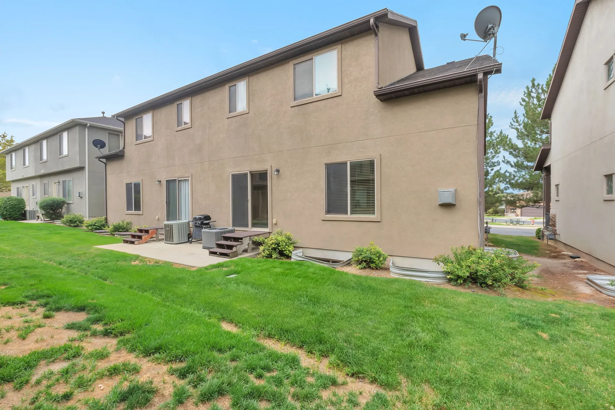 Stucco exterior with multiple windows and a sliding glass door