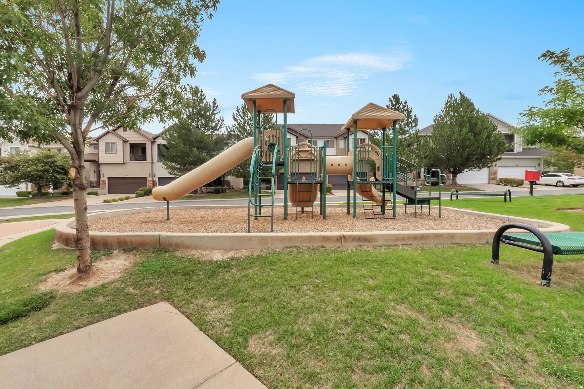 Community playground featuring a multi-level play structure with slides and climbing elements