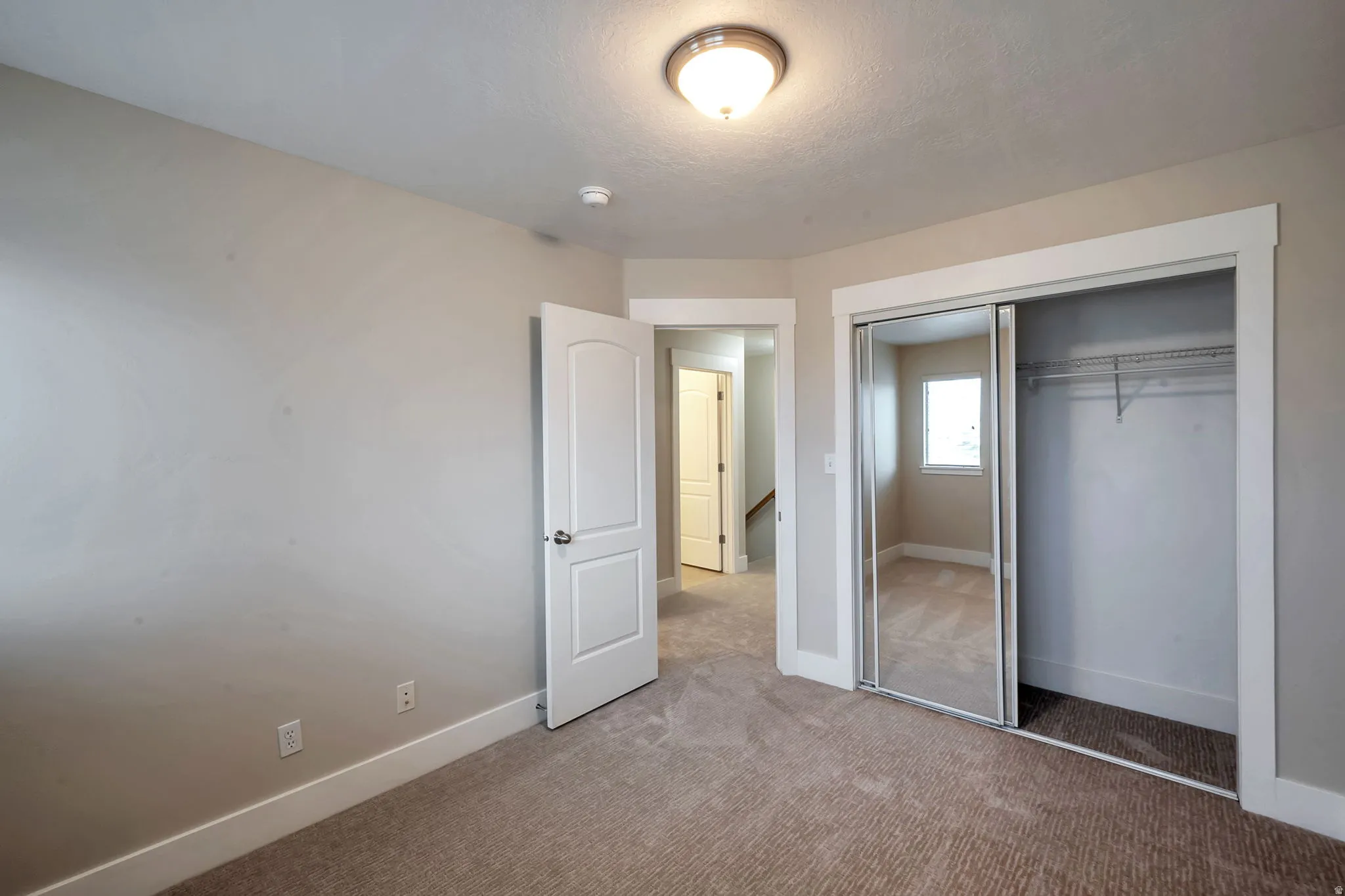 Plush carpet flooring, neutral wall paint, white trim, and a semi-flush mount ceiling light