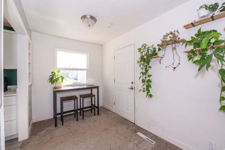 Carpeted flooring, single pane window, flush mount ceiling light, paneled interior door, built-in shelving