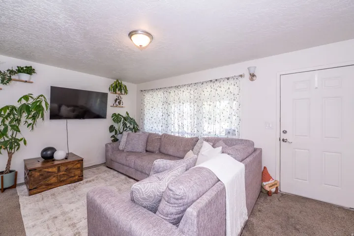 Recessed lighting, wall-mounted television, white paneled entry door, and wall sconce