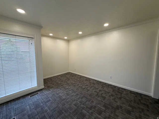 Recessed ceiling lighting, crown molding, white trim, textured walls, and patterned carpet
