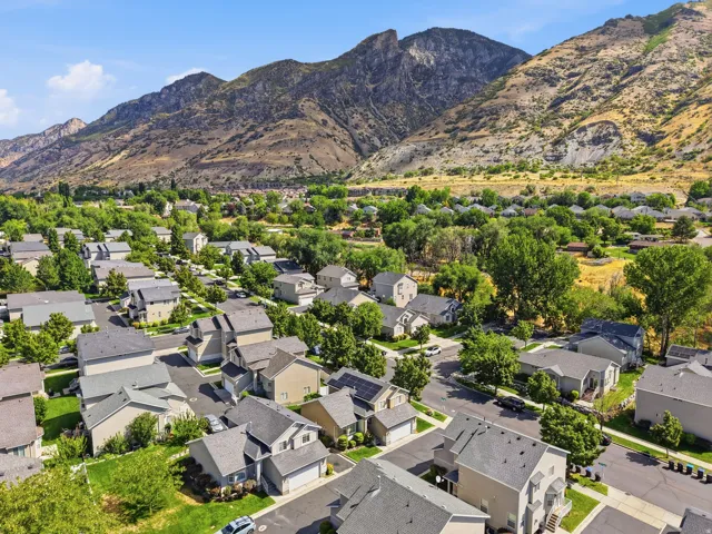 Residential neighborhood with mature trees, surrounded by mountainous terrain
