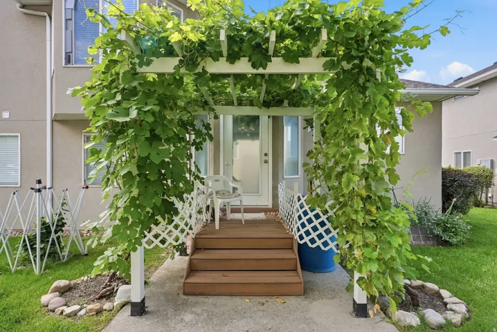 Covered porch entrance featuring a white pergola and lattice detailing