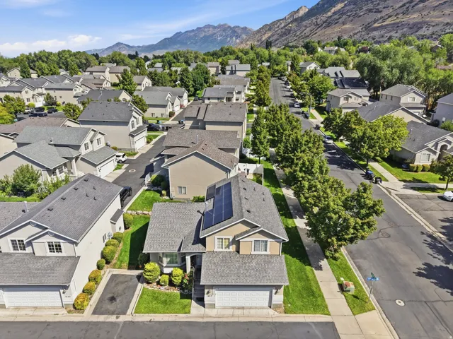 Mountain backdrop, residential street, street trees, green lawns, solar panels