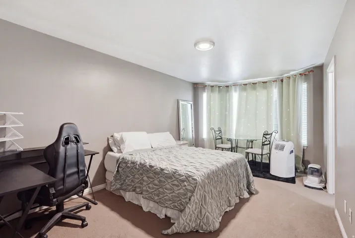 Recessed lighting illuminates neutral-toned walls and carpeted flooring