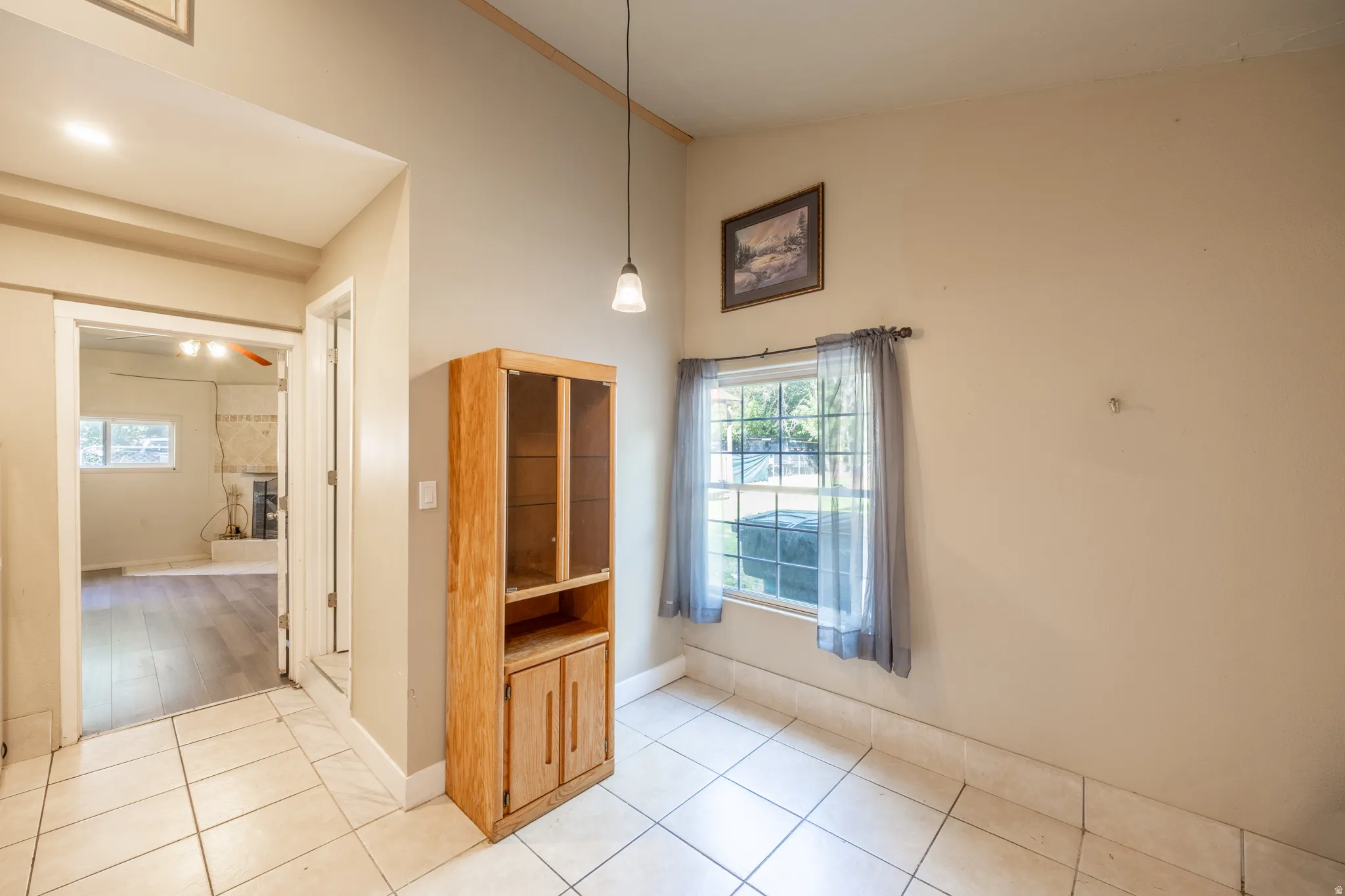 Tile flooring, light-toned walls, pendant lighting, and a single window