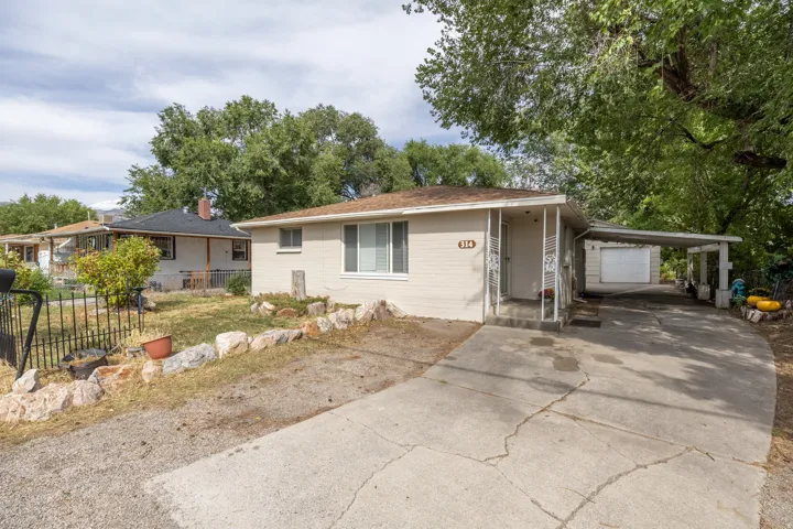 Single-story residence featuring a covered front porch, an attached carport, and a separate garage structure