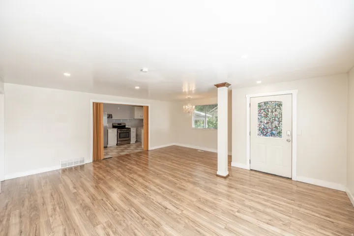 Wood-finish flooring throughout, recessed lighting, and a decorative stained-glass entry door