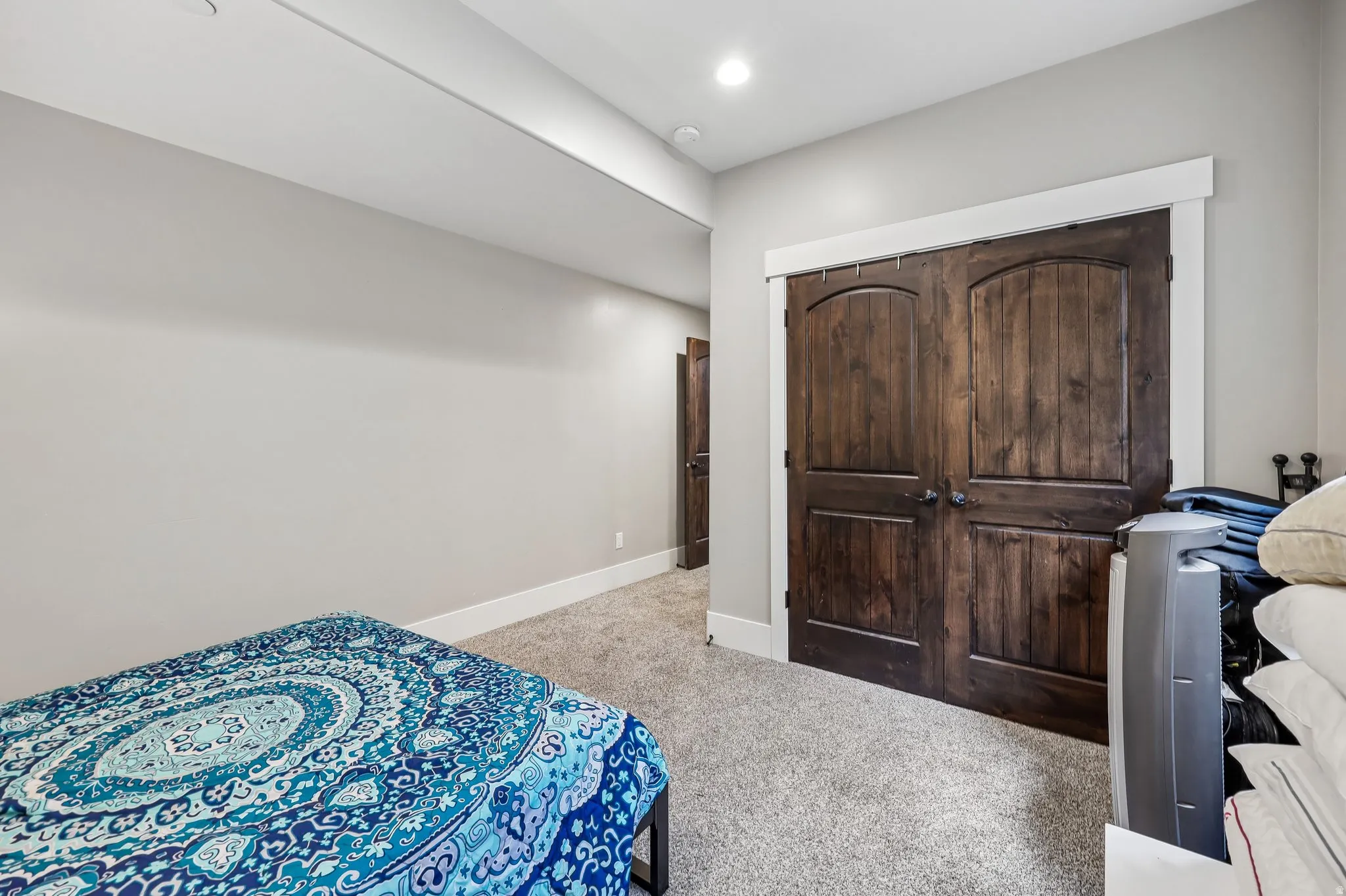 Lower-level guest bedroom with an oversized double closet and space for a king bed, set apart from the main living areas.