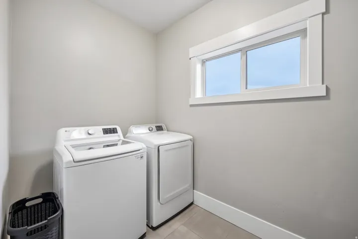 Upstairs laundry room with a side-by-side washer and dryer and folding space, located on the bedroom level.