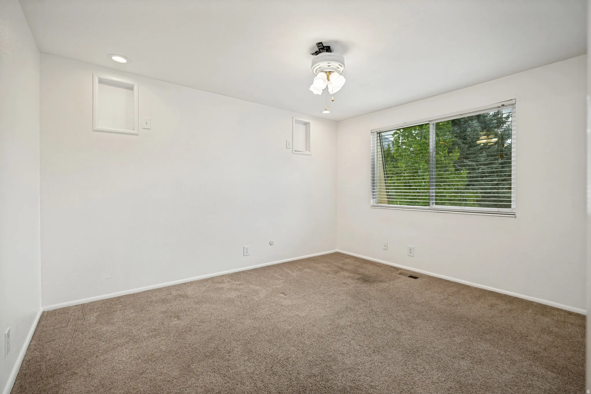 Recessed ceiling lighting, ceiling fan, carpet flooring, and a window with horizontal blinds