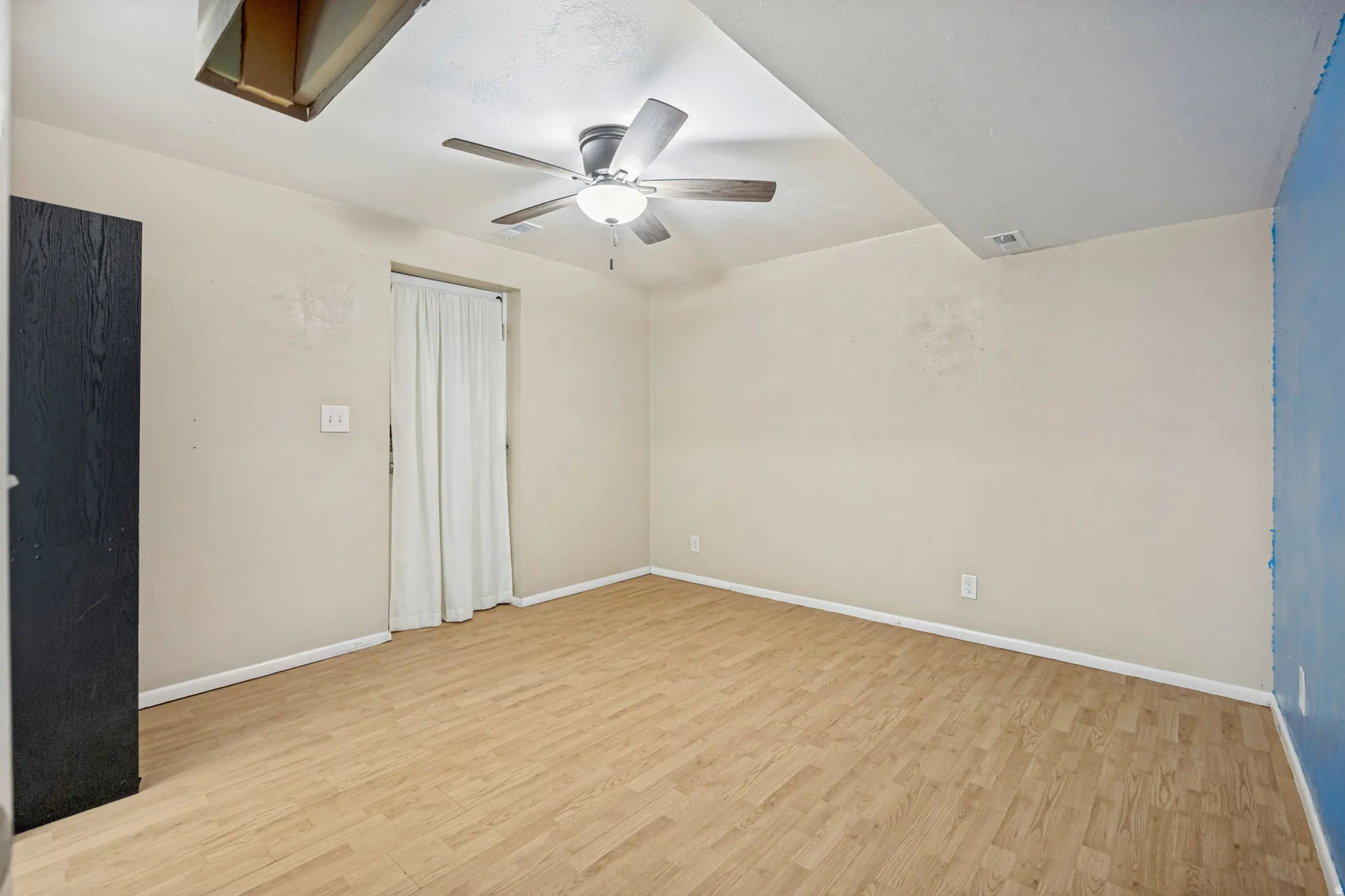 Wood-finish flooring with a ceiling fan and overhead lighting