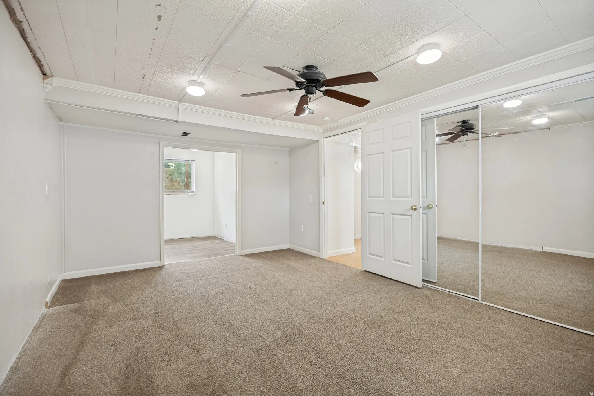 Soft carpet flooring, paneled ceiling, recessed lighting, ceiling fan, and mirrored closet doors