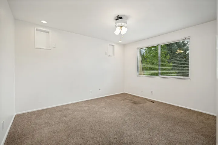 Recessed ceiling lighting, ceiling fan, carpet flooring, and a window with horizontal blinds