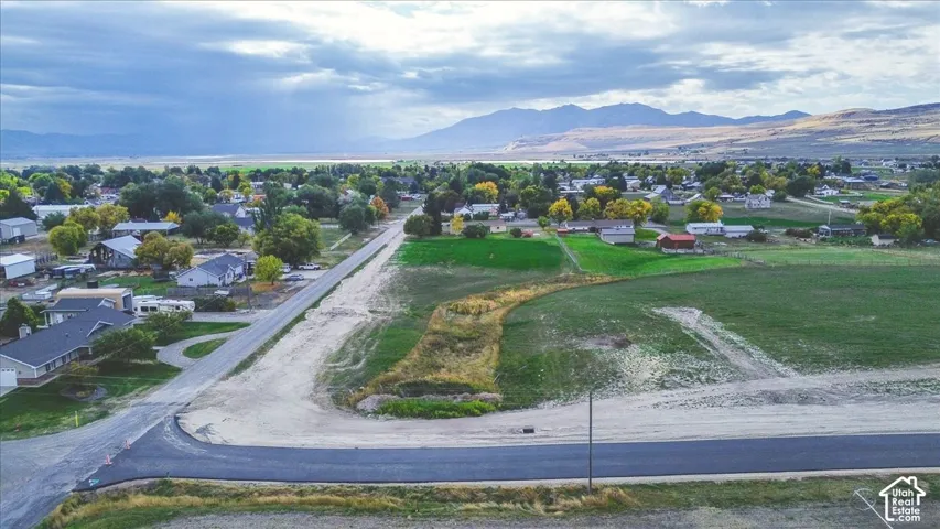 Expansive corner lot featuring paved road access, open terrain, and mountain scenery