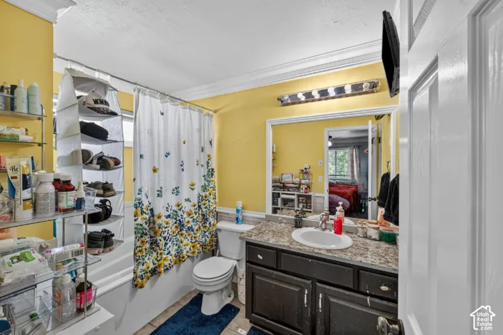 Bathroom featuring a vanity with a drop-in sink, a wall-mounted light fixture, and a toilet