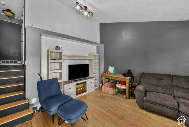 Wood-finish flooring, built-in entertainment unit, and a track lighting fixture
