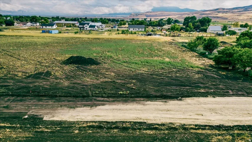 Expansive cleared land parcel featuring a level building area and mountain backdrop