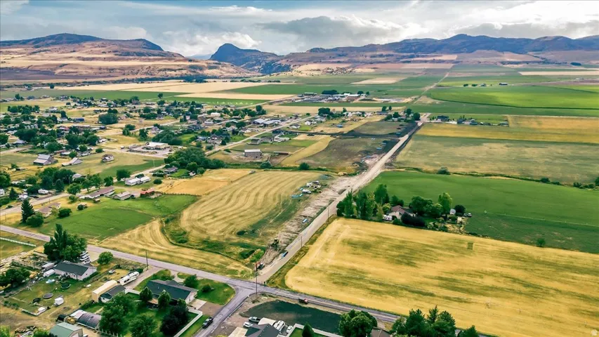 Expansive rural landscape featuring agricultural fields, residential areas, and distant mountainous terrain